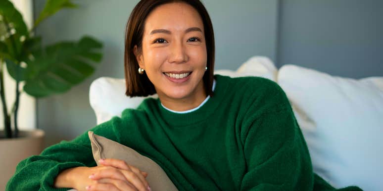 happy confident woman who loves staying home sitting on her couch