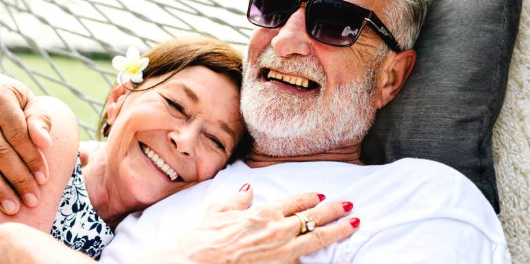 A happy couple in their 60s sharing a playful moment outdoors