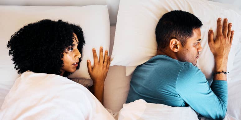 A top view of a frustrated couple lying far apart in bed; a visual representation of the physical distance and lack of intimacy that experts say can signal a marriage is in trouble.