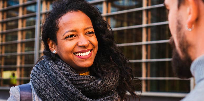 woman in a conversation smiling but ruining a good first impression