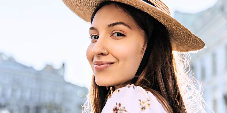 Close-up Portrait of Young Pretty Woman in Straw Hat on Blurred City Background.
