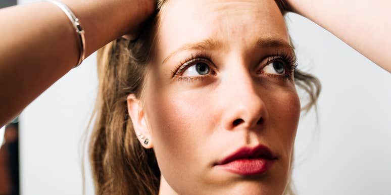 A young woman looking up in deep thought and frustration; a visual representation of analysis paralysis and the mental strain of making a high-stakes decision.