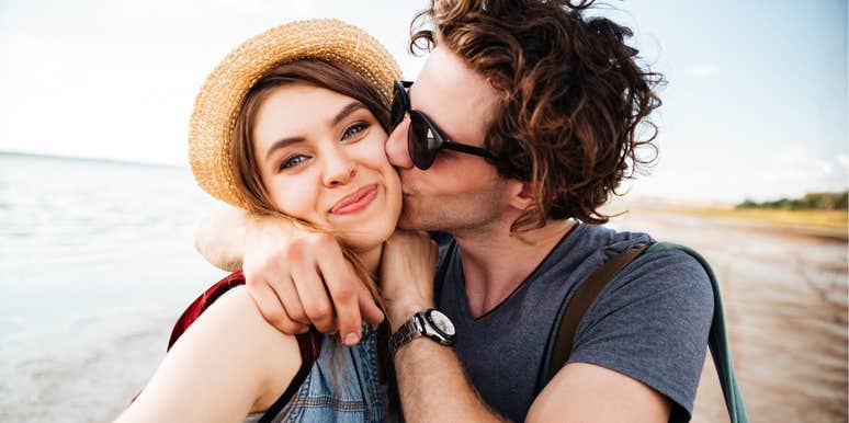 A man kissing a woman on the cheek in a moment of genuine affection, illustrating the small but vital habits that a therapist says distinguish couples who stay together long-term.