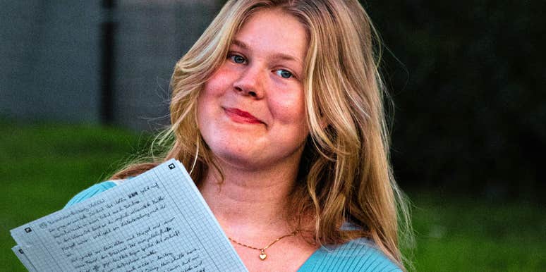 A woman with a list of items to cut from her budget, capturing the 'strategic frugality' needed to retire years ahead of schedule.