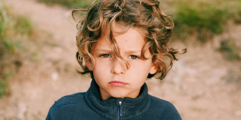 A young boy appearing stoic and pouting, illustrating 'affective blunting' and the psychological barriers to expressing gratitude in childhood.