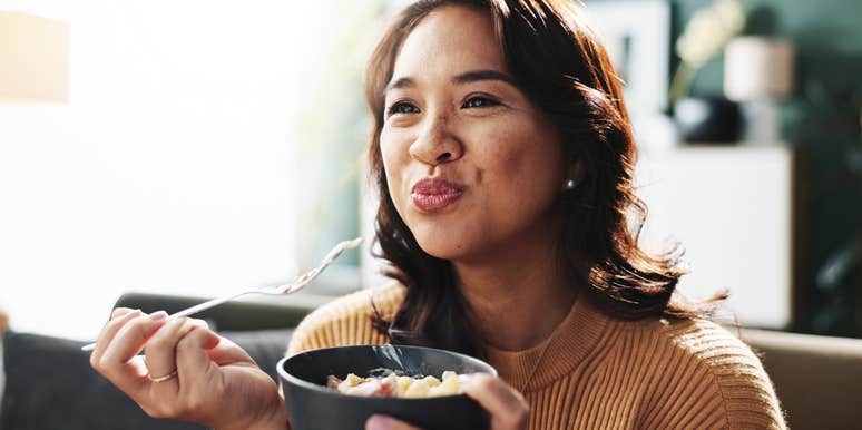 woman eating boiled peanuts on the couch after her divorce