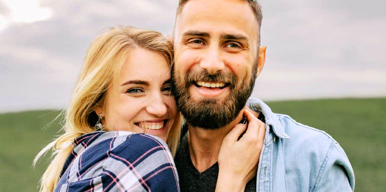A happy man and woman embracing in an open field; illustrating the 'complementary attachment strategies' and hormonal differences—like the roles of vasopressin versus oxytocin—that shape how genders bond.