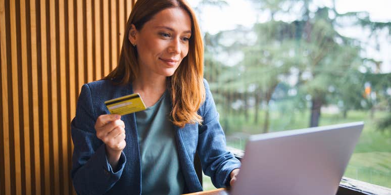 cheap woman holding her credit card refusing to overspend