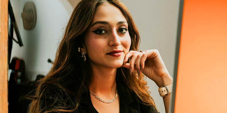 A portrait of a businesswoman looking poised and focused at her desk; illustrating the unapologetic 'me-first' mindset that allows high-performing individuals to maintain productivity without worrying about workplace approval.