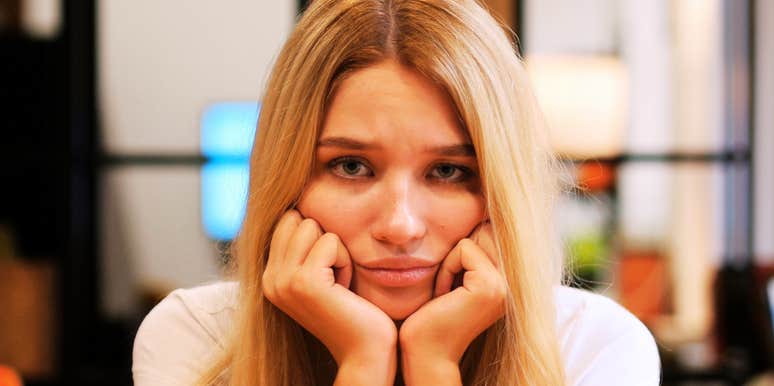 A young woman looking bored and weary while staring at the camera; illustrating the long-term discipline and consistent habits needed to prove trustworthiness to someone you have hurt.