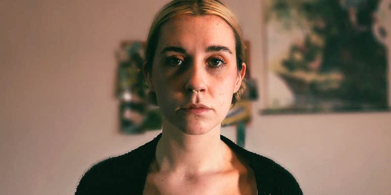 A portrait of a woman indoors with a deeply thoughtful expression; illustrating the quiet strength and the hidden 'disturbing symptoms' that individuals navigate during recovery from toxic relationships.