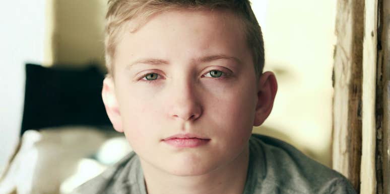 A portrait of a child with a serious, intense stare; illustrating the psychological concept of early fixations and how specific childhood emotional responses can become maladaptive in adult life.