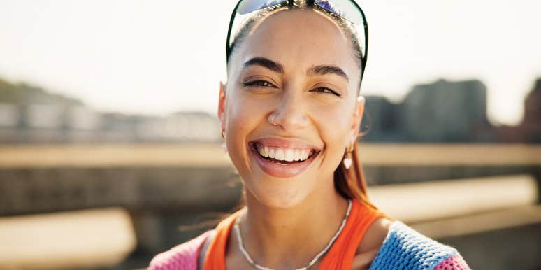 portrait of smiling woman standing outside