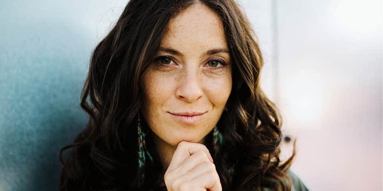A young urban female looking directly at the camera with a relaxed, cheerful expression; illustrating the 'unbothered' nature of high-IQ individuals who prioritize personal values over external validation.