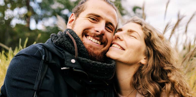 A joyful man and woman looking at each other with genuine affection and ease; illustrating the rare signs of a deep, secure attachment that most people strive to find in a partner.