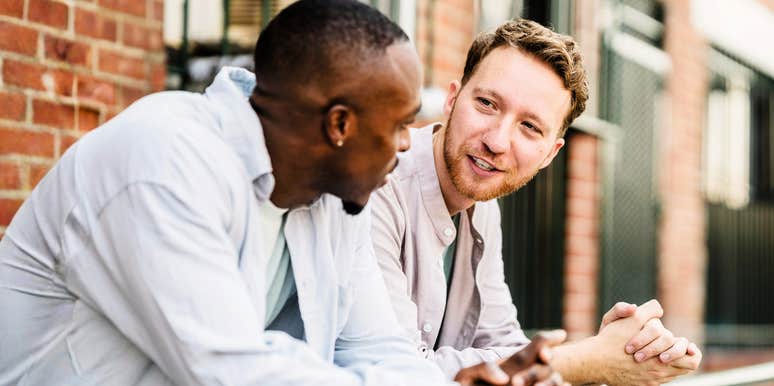 Two men talking in a professional setting with open and honest body language; illustrating the 'steady presence' and ethical interpersonal habits that experts identify as the most respected markers of a trustworthy individual.