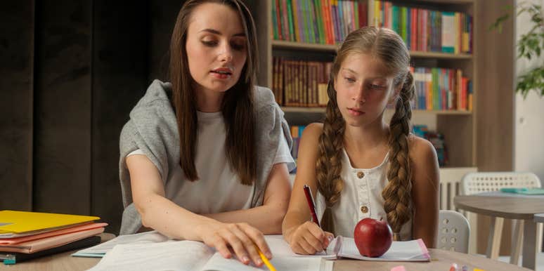 teacher helping student with work sitting at desk