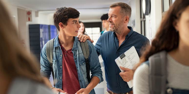 teacher talking to student in school hallway