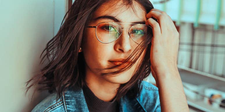 A portrait of an intelligent-looking woman in glasses; illustrating the 'unconscious competence' and ease of focus that characterize individuals with superior neural connectivity and pattern recognition skills.