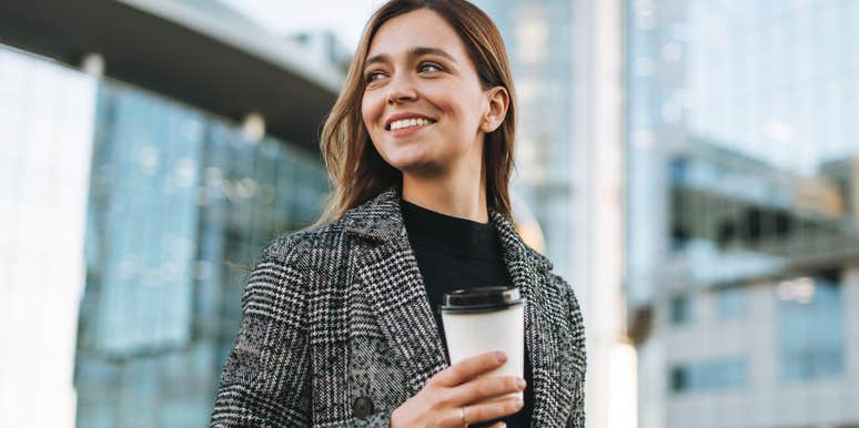 young woman carrying coffee cup