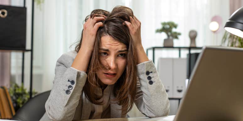 stressed worker sitting at desk in front of laptop
