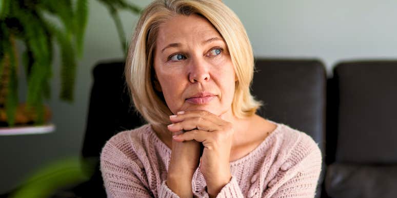 sad baby boomer woman ruminating at home