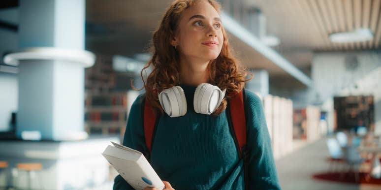 young student wandering through school library