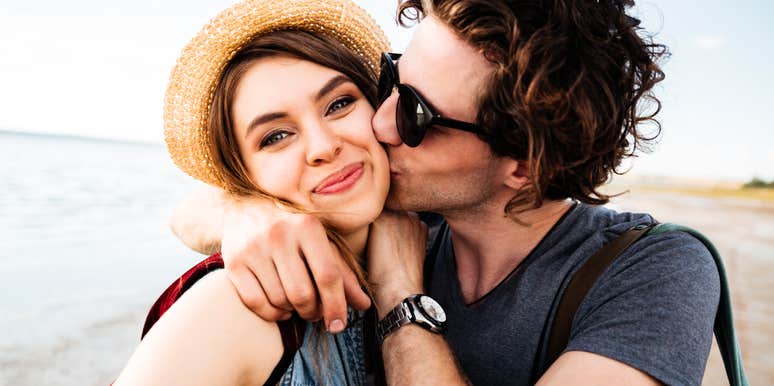 Romantic couple hugging on the beach with their bodies close together, reflecting deep attraction and emotional closeness