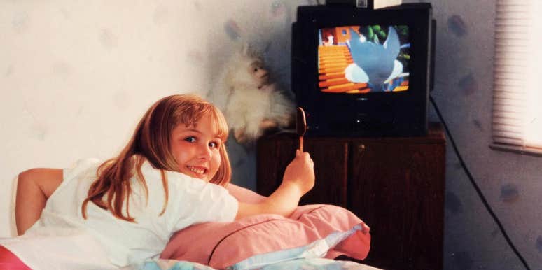 A vintage photograph of a young child sitting close to a retro box television set in a dimly lit living room; a visual representation of 'the unmonitored viewer' and the nostalgic movies Gen-X kids grew up loving.