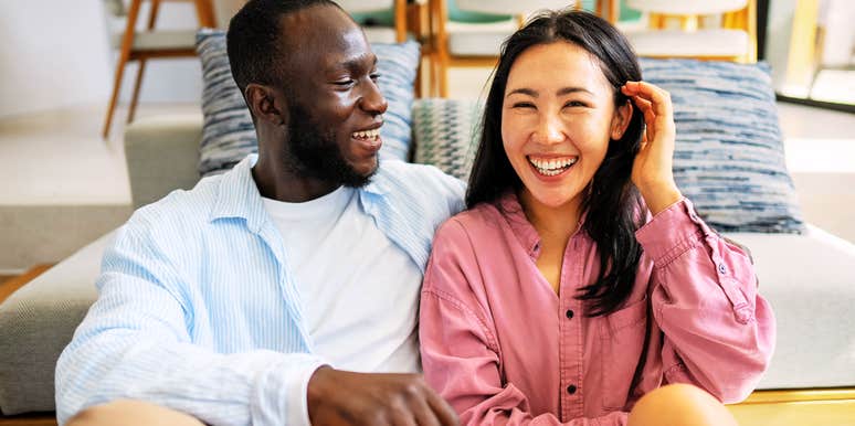 A diverse mature couple smiling warmly and bonding during a loving, tender moment together; illustrating 'evolutionary attraction' and the deep emotional safety that outranks physical traits in long-term partnership.