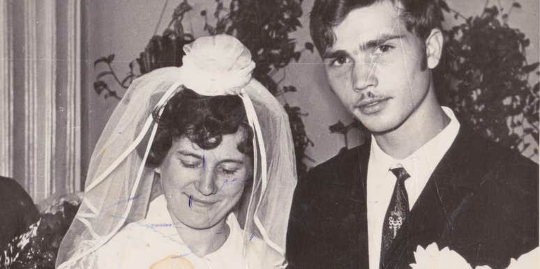  A vintage 1960s black and white photograph of a bride and groom exchanging rings; a visual representation of 'institutional formality' and the old-fashioned marriage ideals that Millennials and Gen-Z no longer believe in.