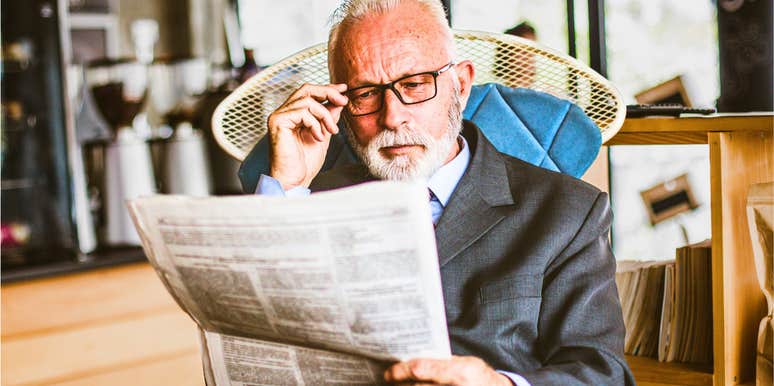 older man reading a newspaper feeling nostalgic for the past