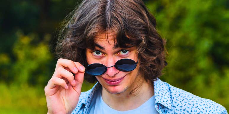 man with bad character smirking lowering his sunglasses