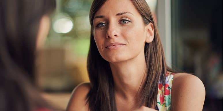 woman with slightly snide look on her face doesn't care about her friend who is talking 