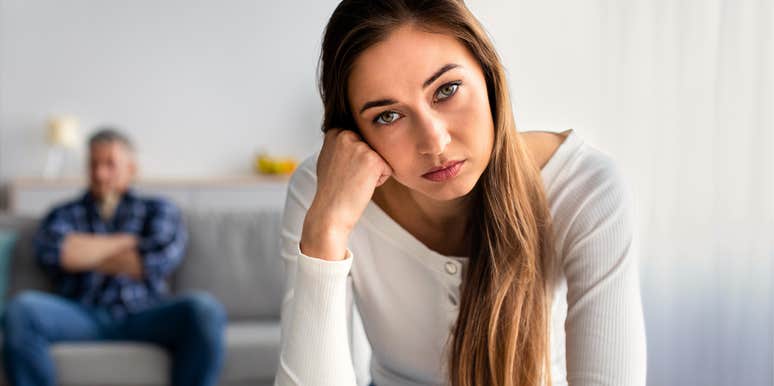annoyed woman expecting her husband in background to make sacrifices for her