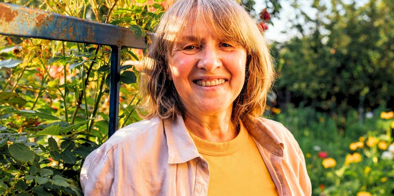 beautiful older woman standing in her garden