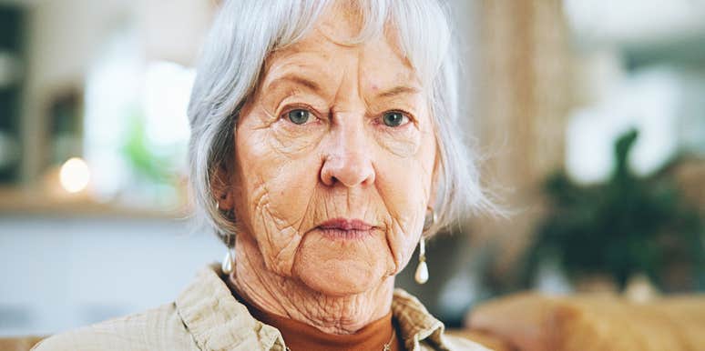 Wealthy older woman looks sternly at camera