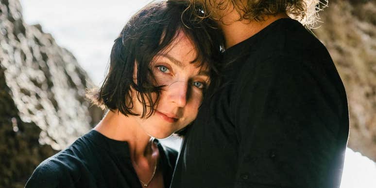 A woman resting her head gently on a man's chest in a peaceful bedroom setting; a visual representation of 'the secure haven' and the rare emotional qualities of women men never quite get over.