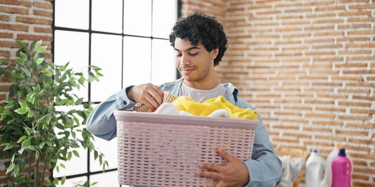 young man holding basket of laundry