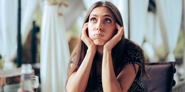 Single woman looks exhausted and annoyed at someone else's wedding 