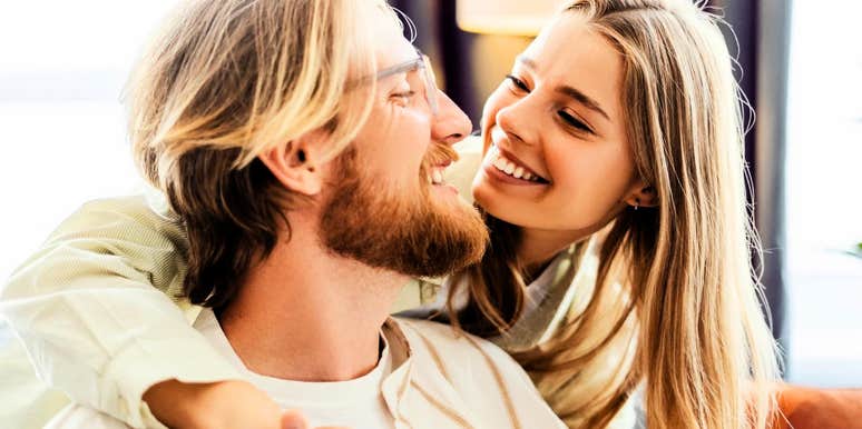 Close-up of a happy couple sharing a deeply connected, intimate gaze while sitting together inside