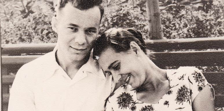 A vintage 1950s black-and-white photograph of a young couple huddled together on a bench in a summer garden; a visual representation of 'the foundational affection' that blooms into lifelong marital success.