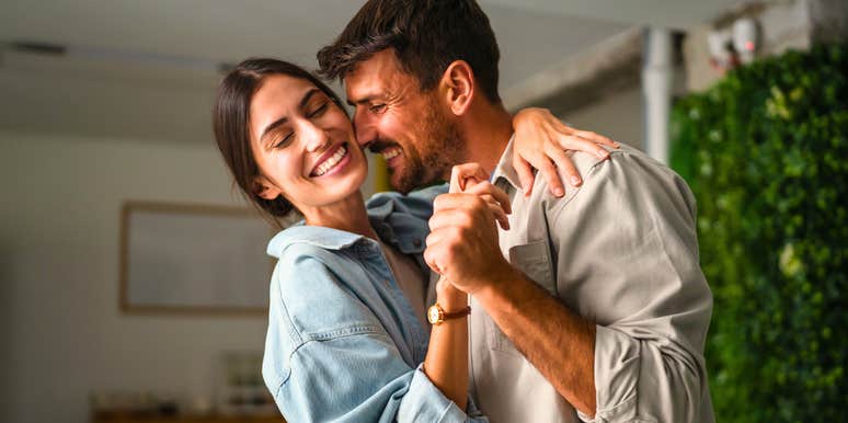 husband who feels appreciated dancing happily with wife at home