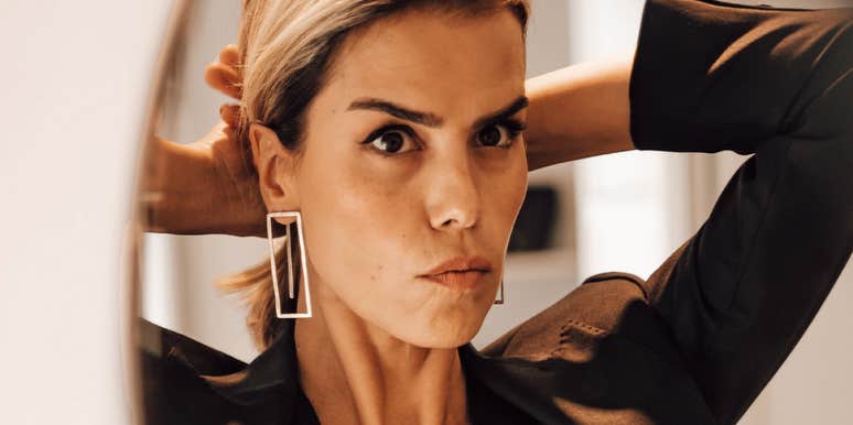 A close-up portrait of a well-dressed person calmly adjusting her blazer before leaving for work, reflecting emotional resilience, self-possession, and focused clarity.