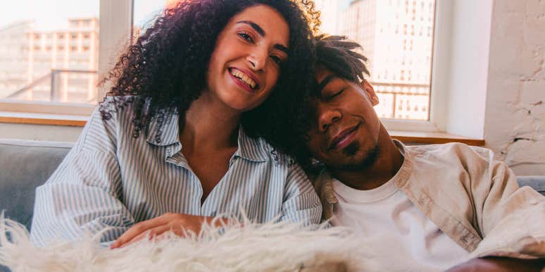 smiling woman sitting next to her ex on the couch