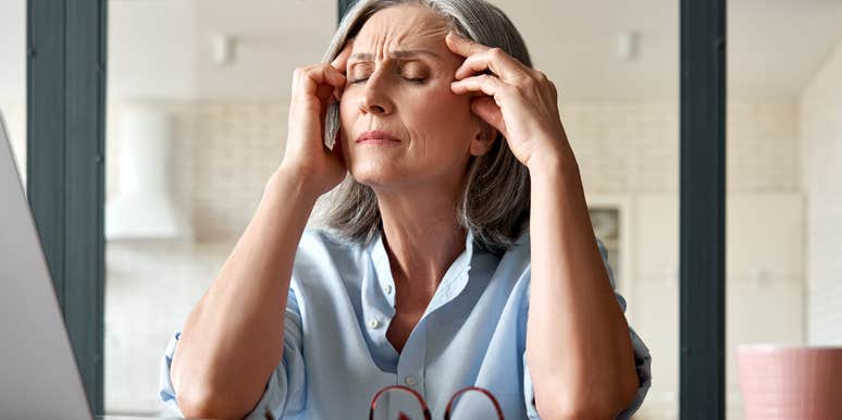 Middle-aged woman looking mentally and emotionally frustrated at her desk