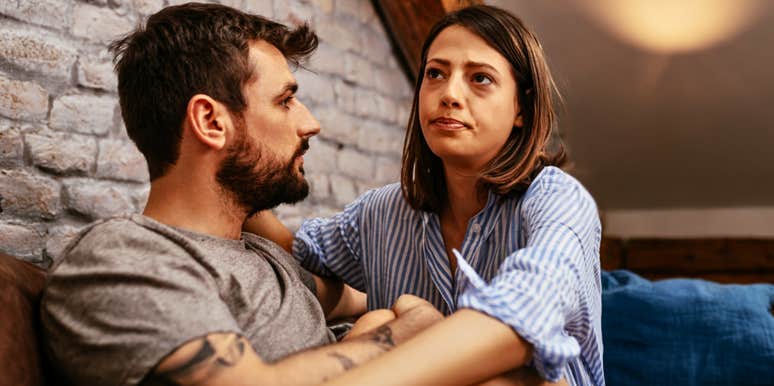 Couple in a relationship that makes them both feel unseen looking sad on a couch 