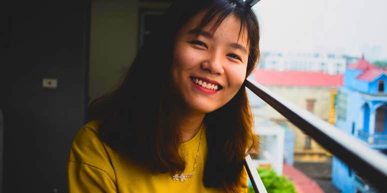 friendly smiling woman standing on a balcony