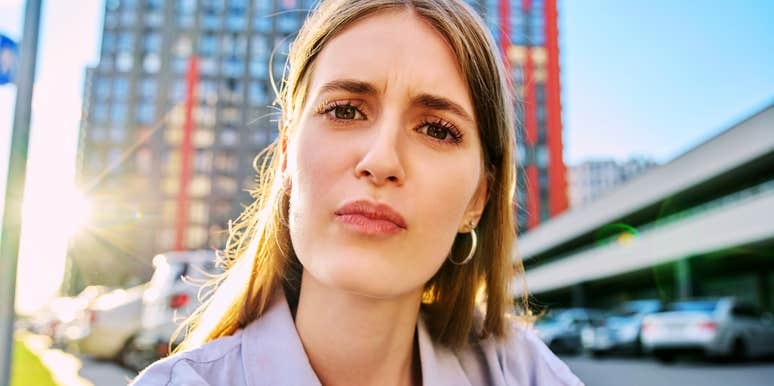 A young woman looking into a web camera with a puzzled, unsure expression, symbolizing communication breakdowns, low emotional intelligence, and interpersonal friction.