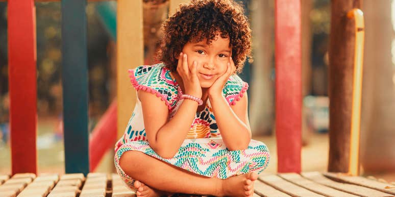 smiling child on the playground sitting 